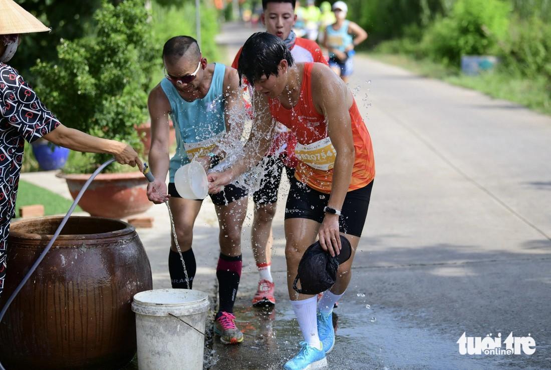 Under the hot sun, runners are refreshed by the heartwarming actions of the people of Can Giuoc District. Along many routes, runners are cooled down with water buckets or hoses, and even "showered" by locals, bringing a sense of comfort and ease to continue their journey to conquer the GreenUP Marathon - Long An Half Marathon 2024